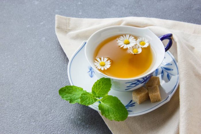 cup-chamomile-tea-with-sugar-cubes-leaves-high-angle-view-cloth-min